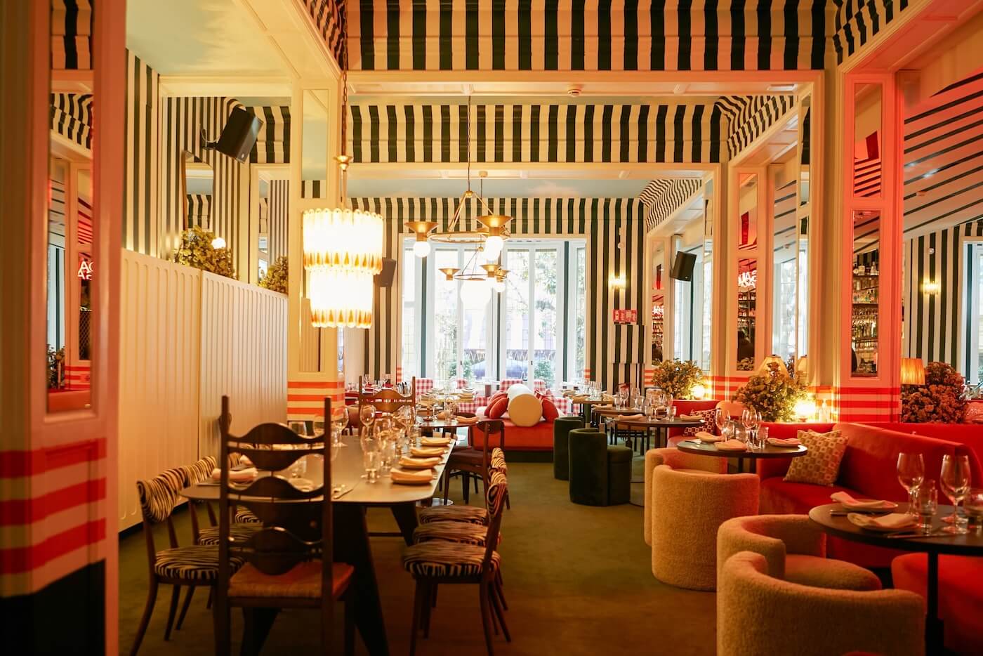 Interior del restaurante Gala en Barcelona con diseño colorido, textiles a rayas y mobiliario ecléctico.