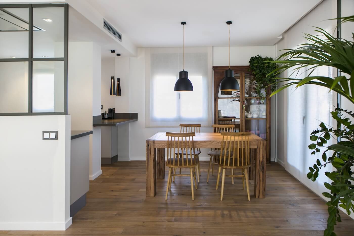Comedor del piso reformado en Sabadell con mobiliario de madera, luz natural y estilo cálido y funcional.