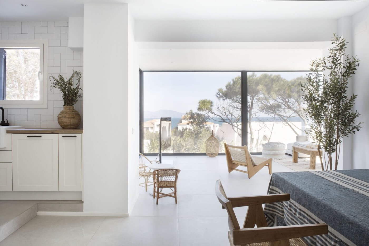Salón comedor de estilo mediterráneo con grandes ventanales y vistas al mar en una casa en la Costa Brava.