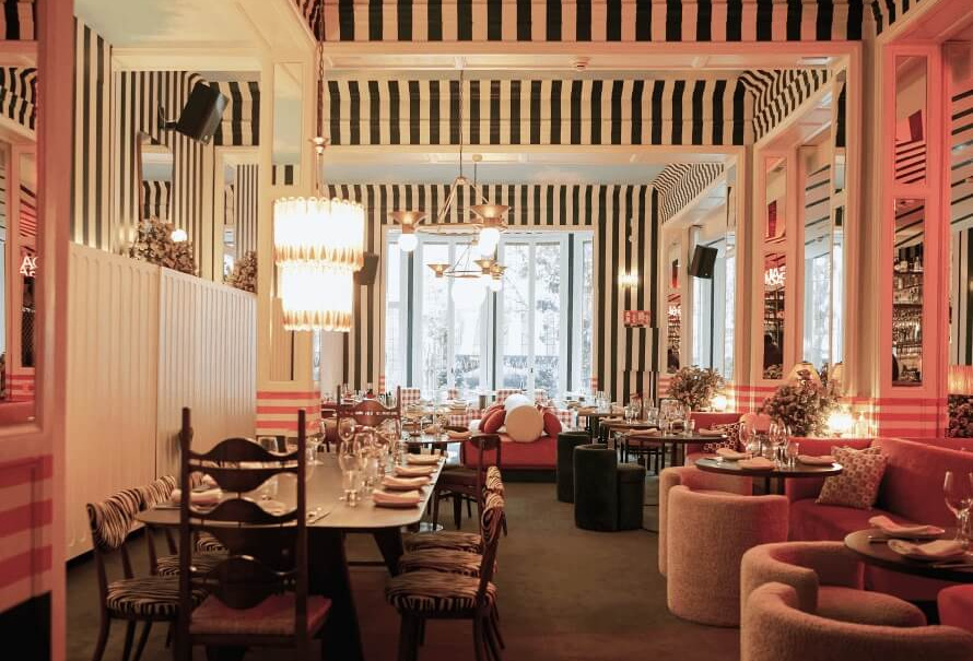Sala principal del restaurante Gala con diseño escenográfico, telas a rayas, mobiliario curvo y decoración en tonos cálidos.