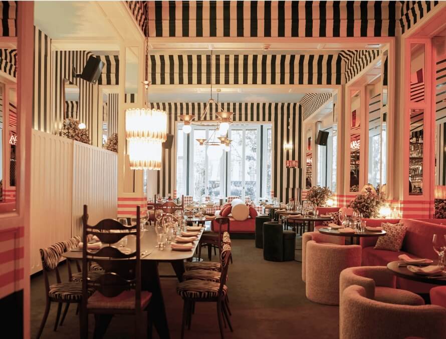 Sala principal del restaurante Gala con diseño escenográfico, telas a rayas, mobiliario curvo y decoración en tonos cálidos.